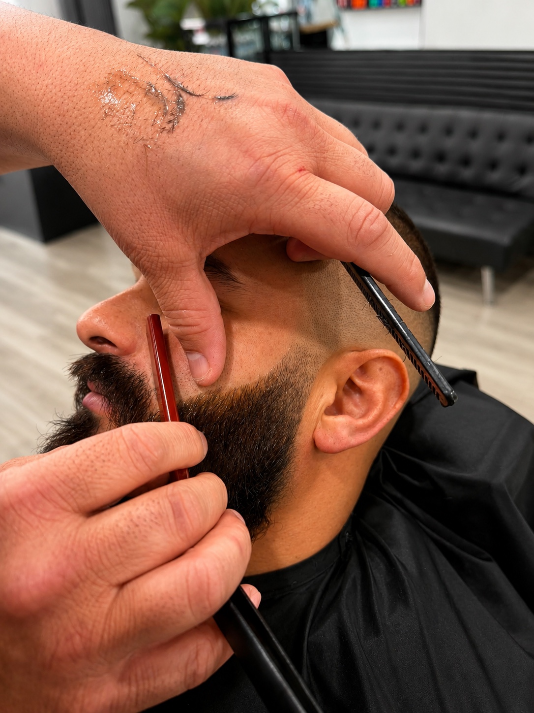 Barber trimming a client's beard at Barber Jacks, Gunnedah